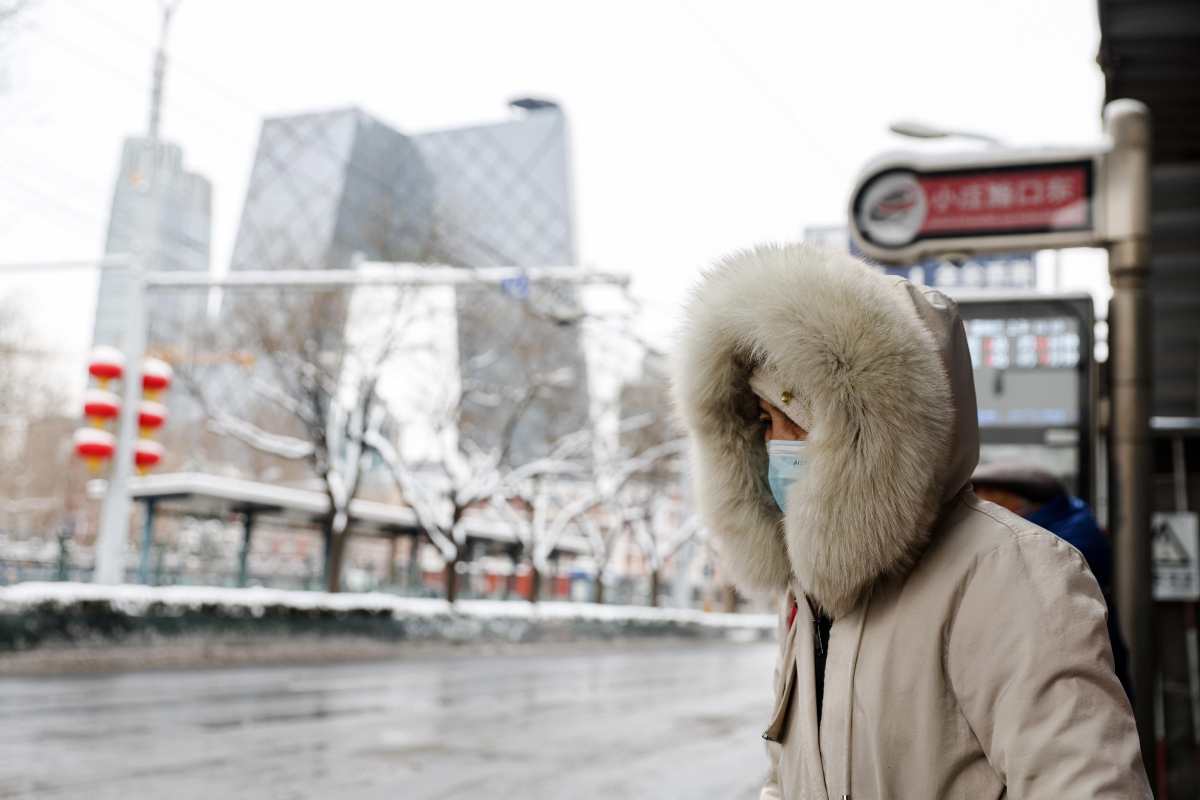 Mujer china en pleno temporal de nieve en Beijing.